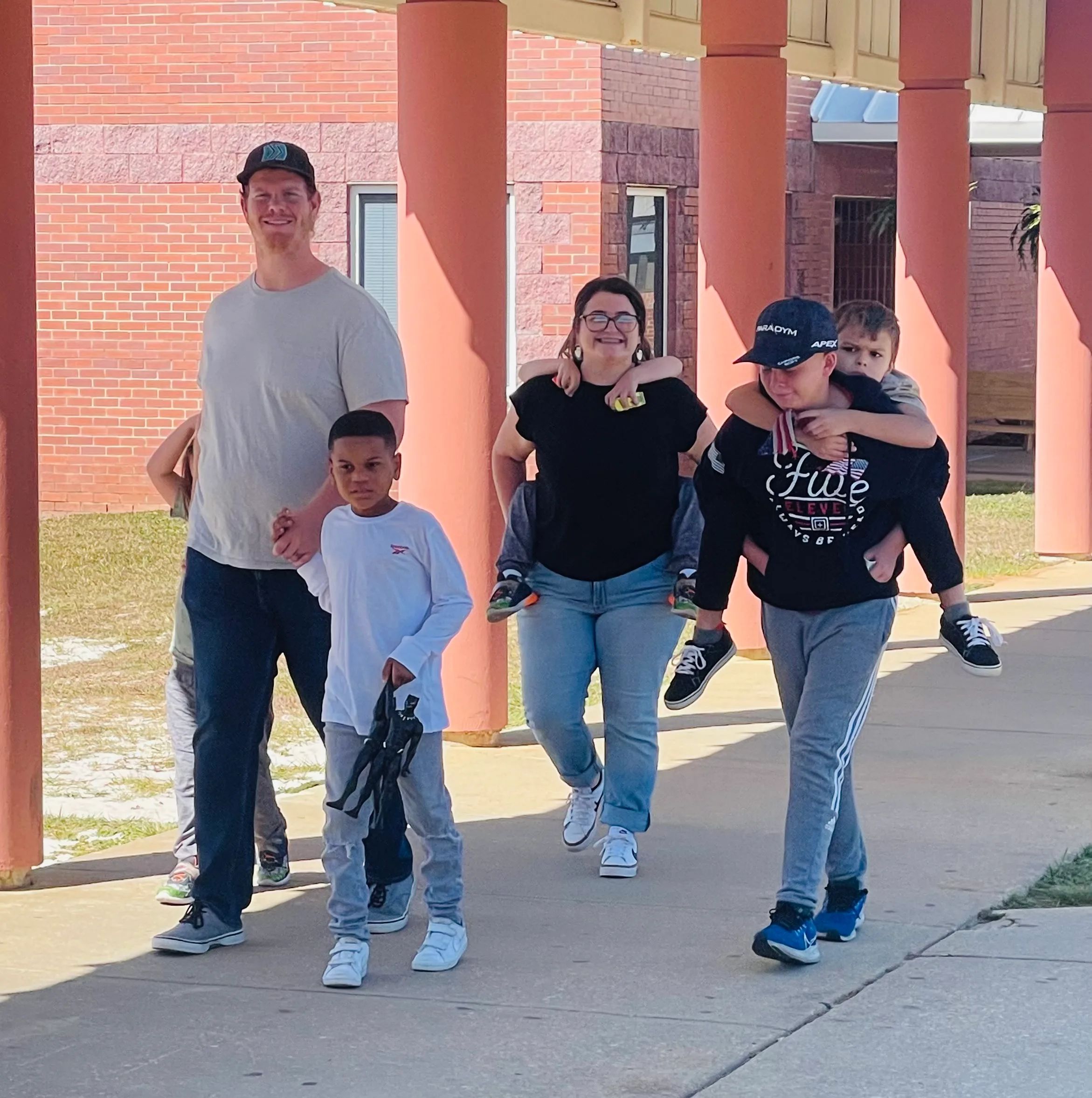 Merrie walking on a school campus with her students