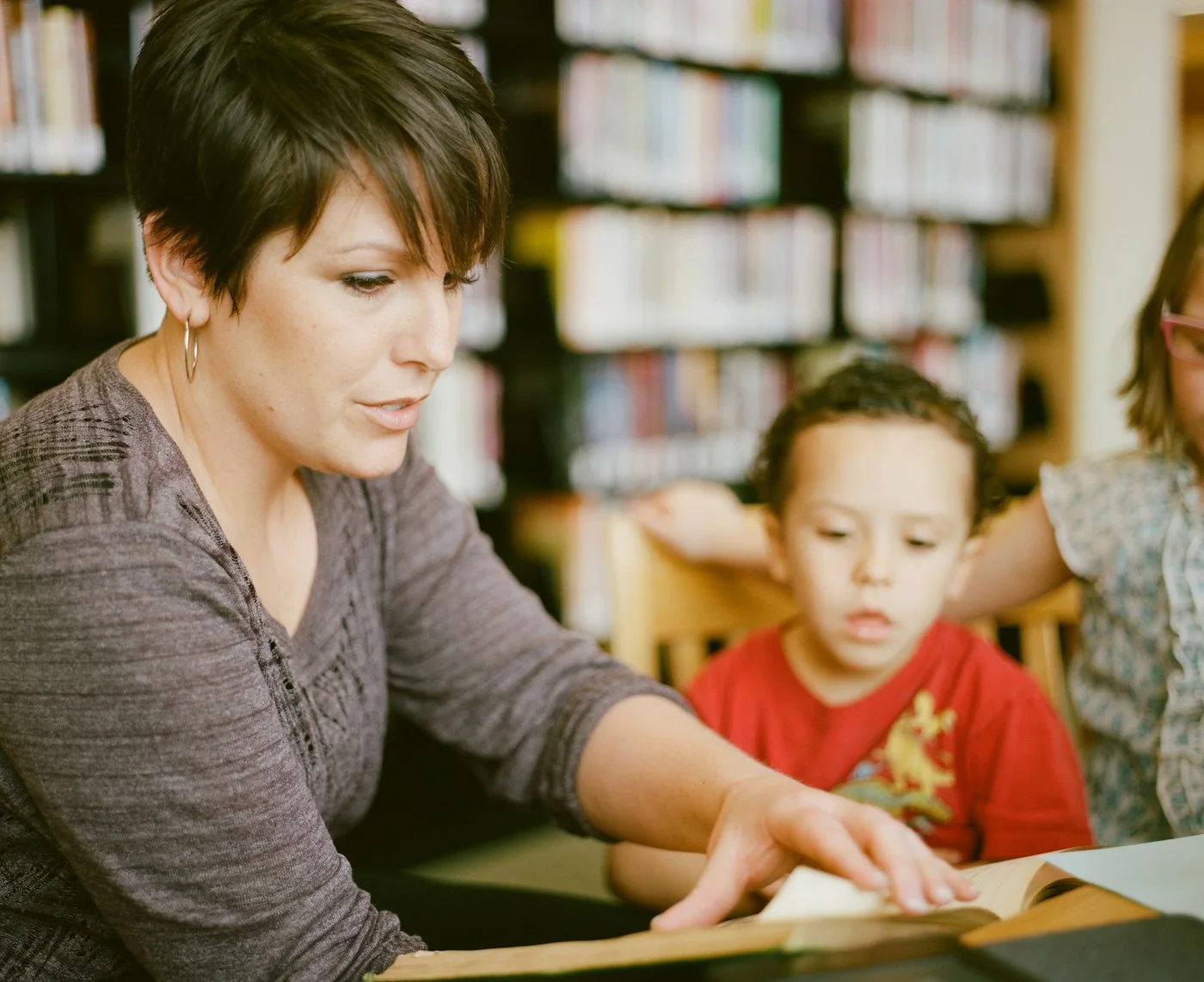 A tutor working one-on-one with a young student over a book