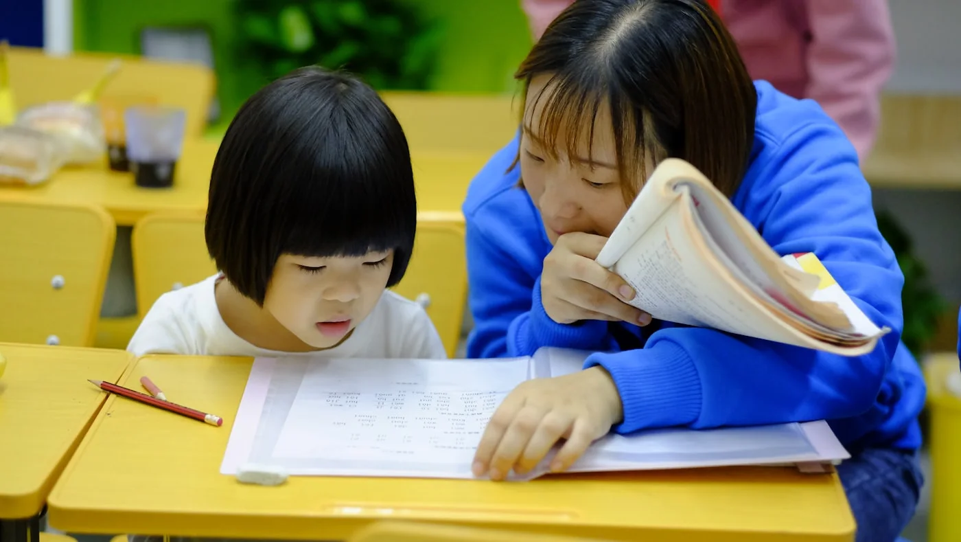 A tutor working through a lesson with a young student